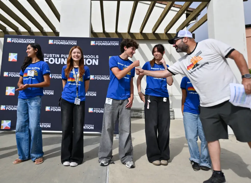 Camp Director Erick Fineberg fist bumps intern Simon McDougal before...