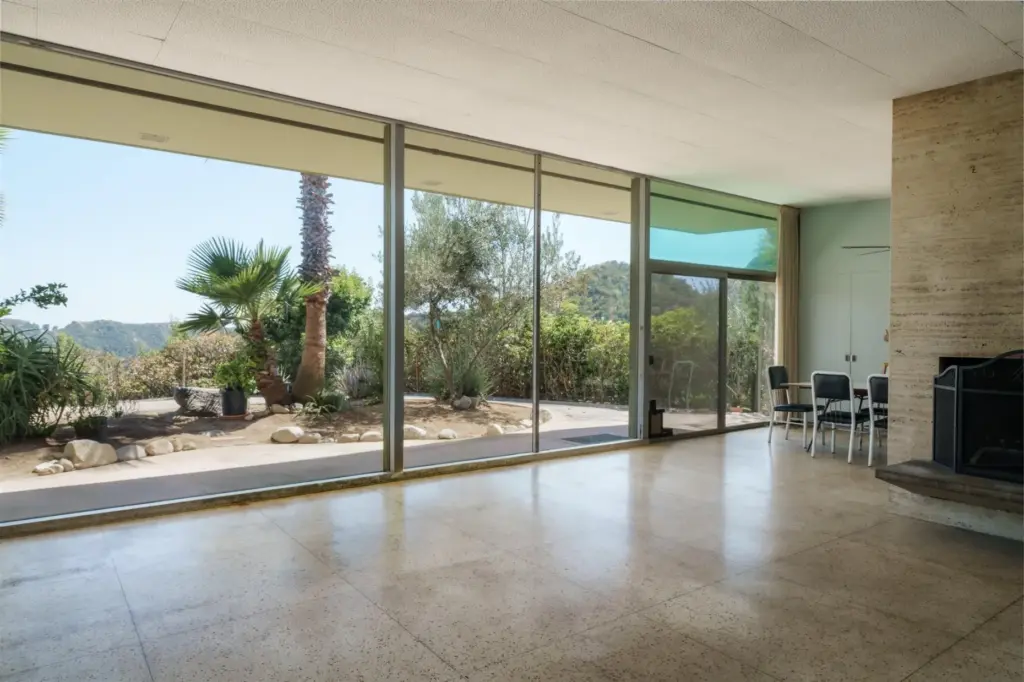 Floor-to-ceiling glass walls frame the backyard and views of the...