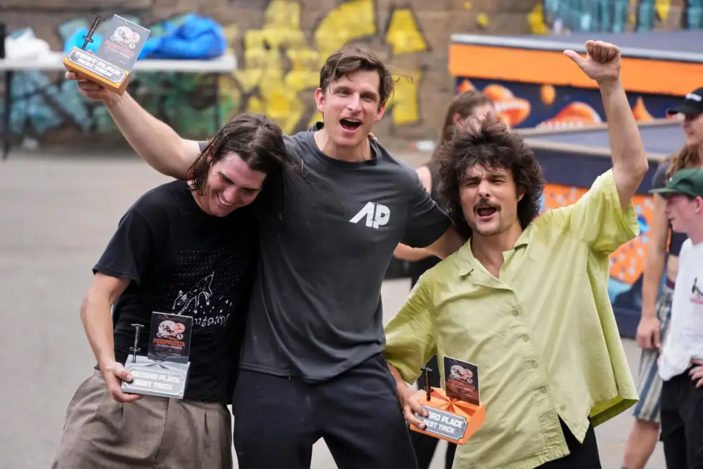 Extreme pogo athlete Michael Mena, center, celebrates his first place...