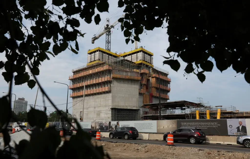 Vehicle traffic moves past construction of the Obama Presidential Center...