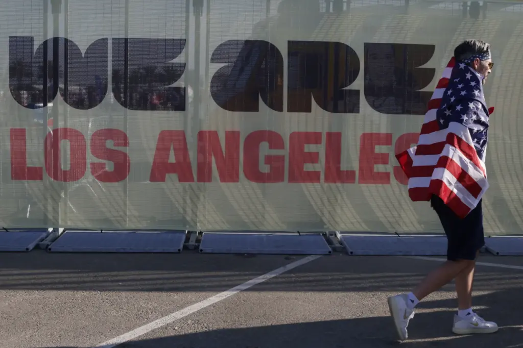 A fan draped in an American flag arrives to watch...