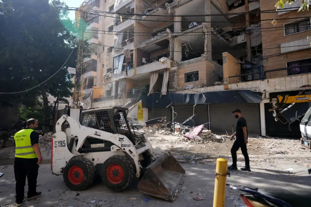 Municipality workers use a skid loader as they remove the...