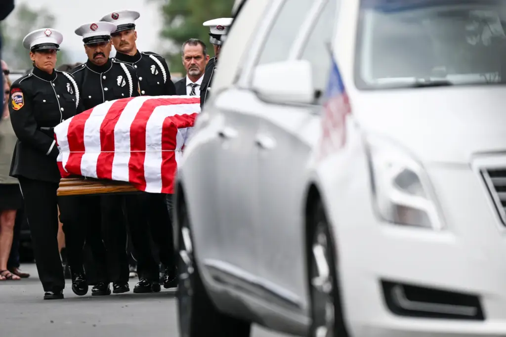 Cal Fire officers carry the caskets of Assistant Chief Josh...