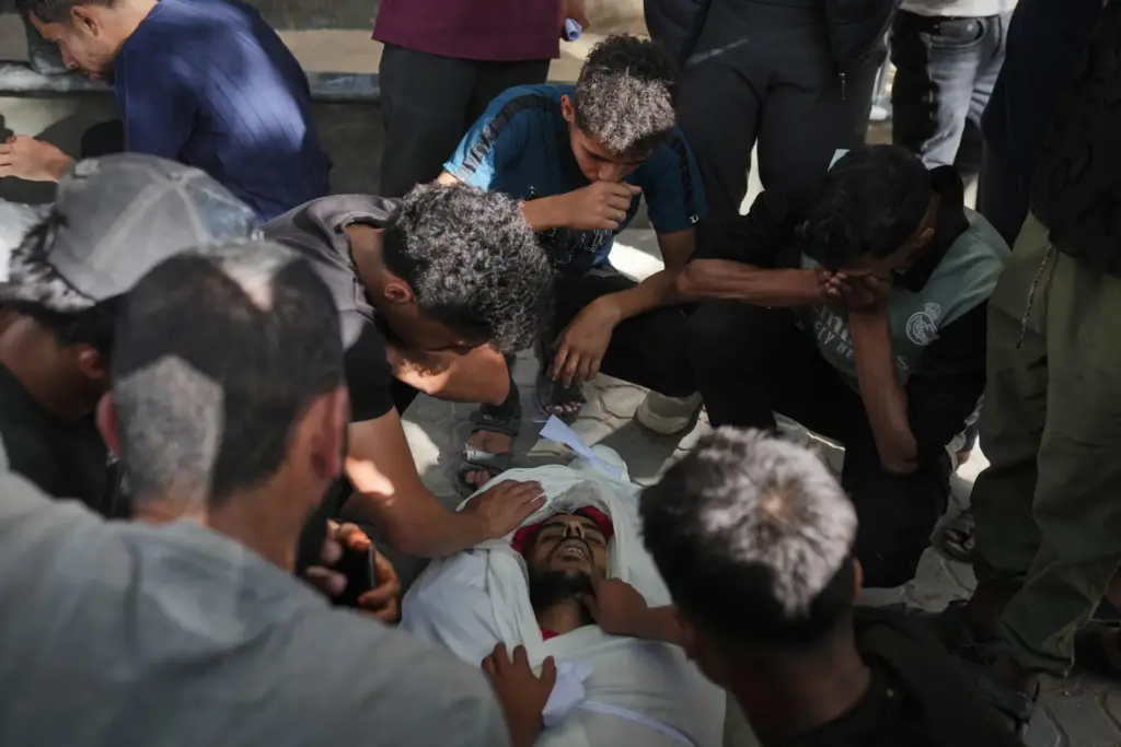 Mourners gather around the bodies of Palestinians killed in an...