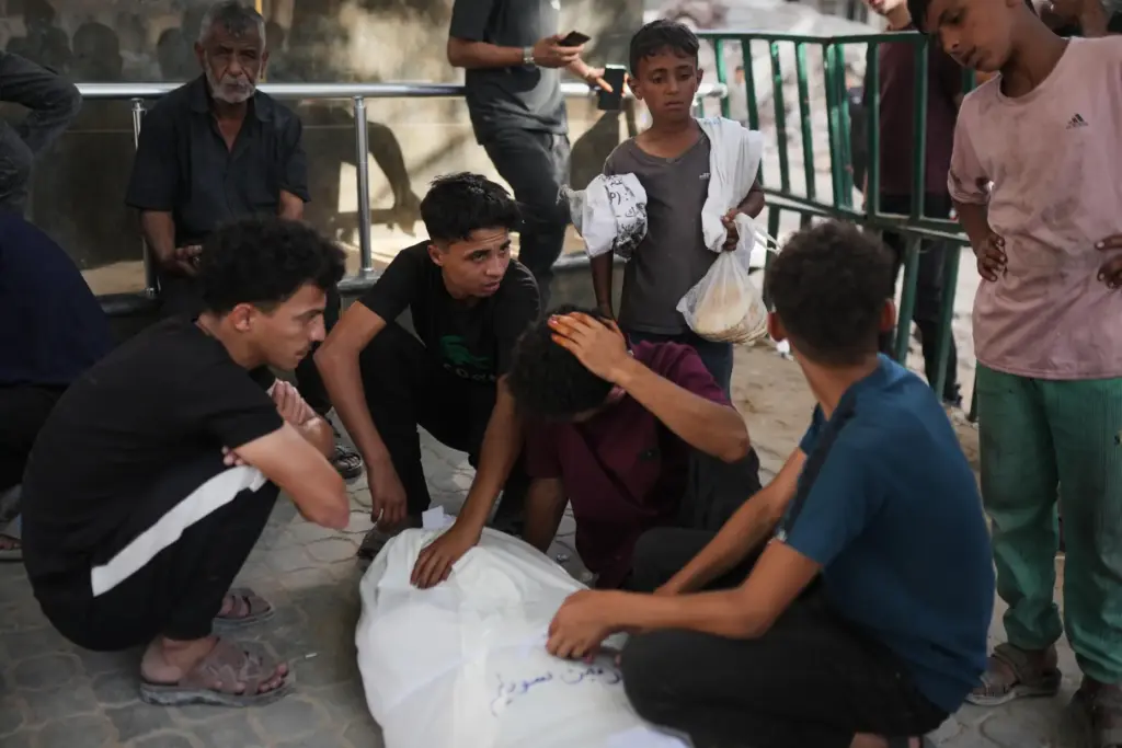 Mourners gather around the bodies of Palestinians killed in an...