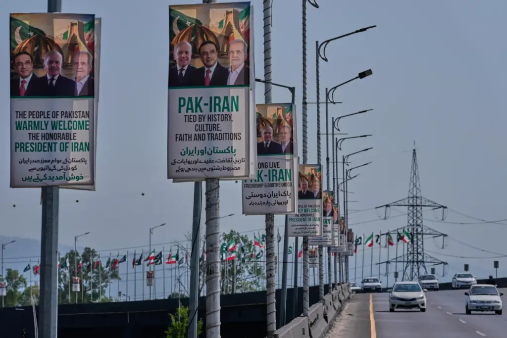 Vehicles drives past welcoming billboards in Islamabad.