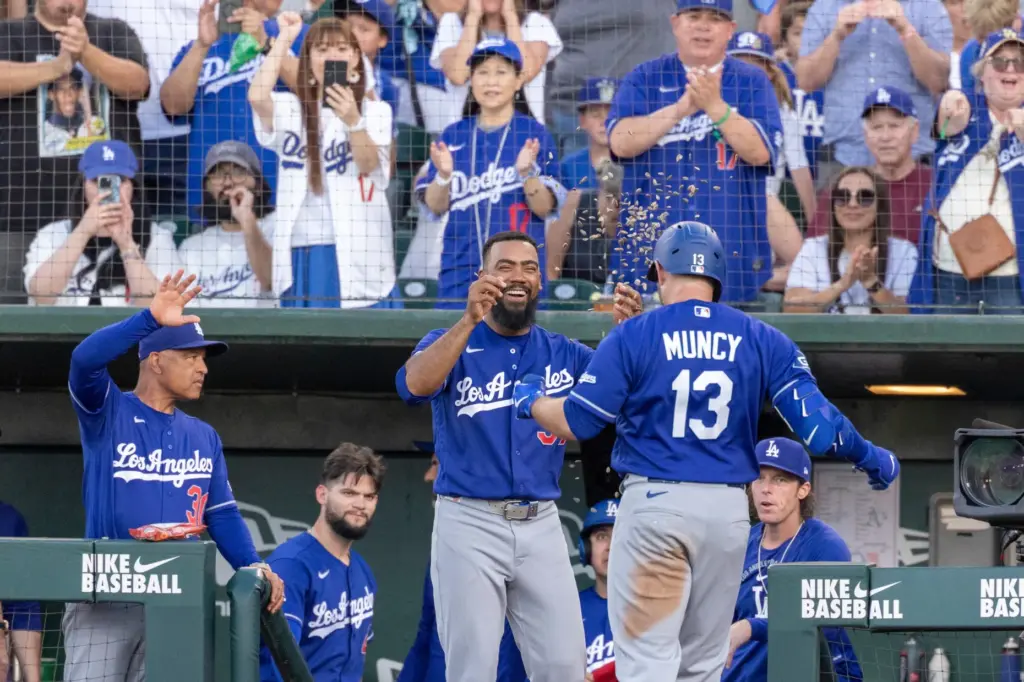 The Dodgers’ Teoscar HernÃ¡ndez, center, celebrates as Max Muncy (13)...