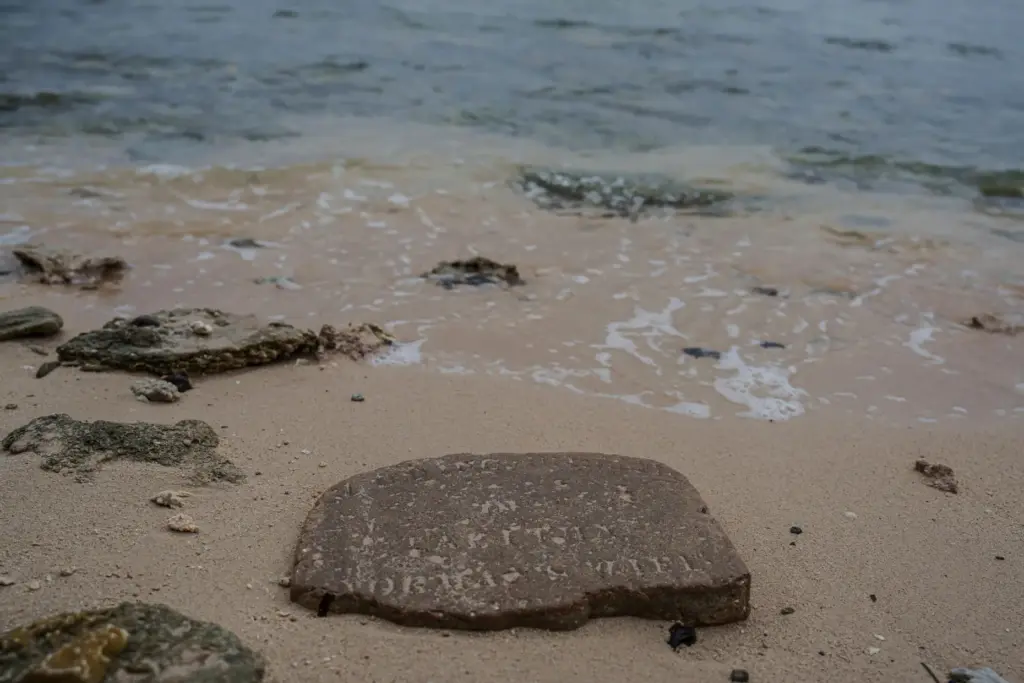 FILE – A gravestone lies near the shoreline on Pele...