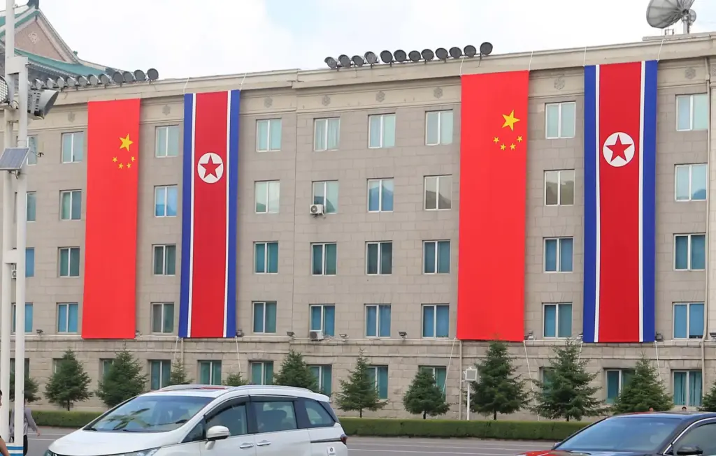 A building is decorated with the flags of China and North Korea in Pyongyang.