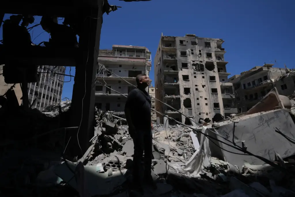 Resident Adnan Kaour stands amid debris outside his apartment building,...
