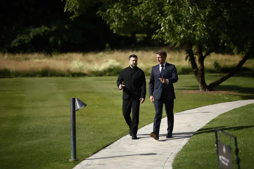 French President Emmanuel Macron walks with Ukrainian President Volodymyr Zelenskyy.