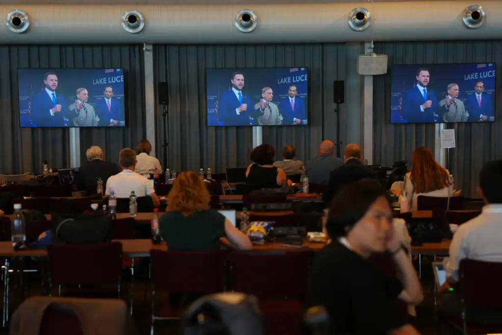 Members of the media watch screens broadcasting the Iran US...