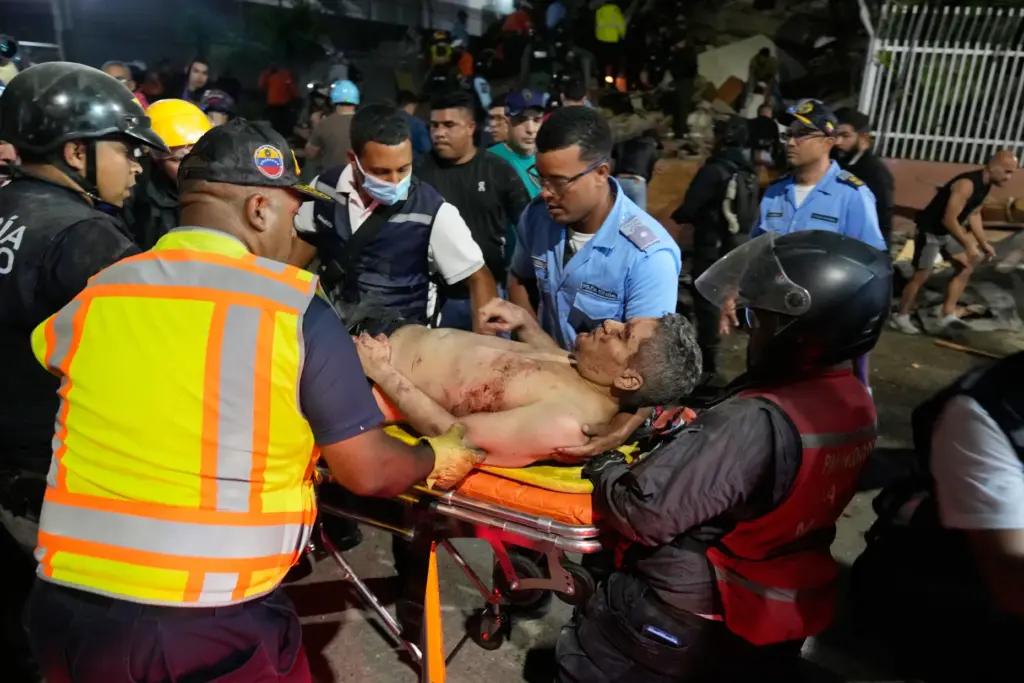 Rescue worker carry an injured man after an earthquake in...
