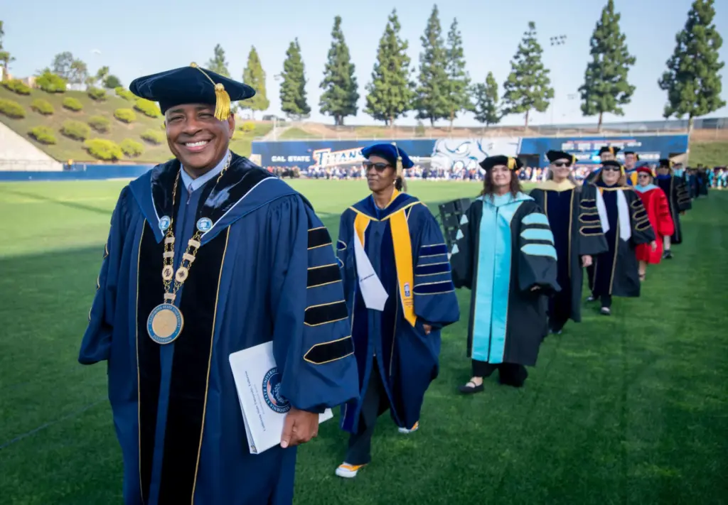 School president, Ronald S. Rochon, leads the way in to...