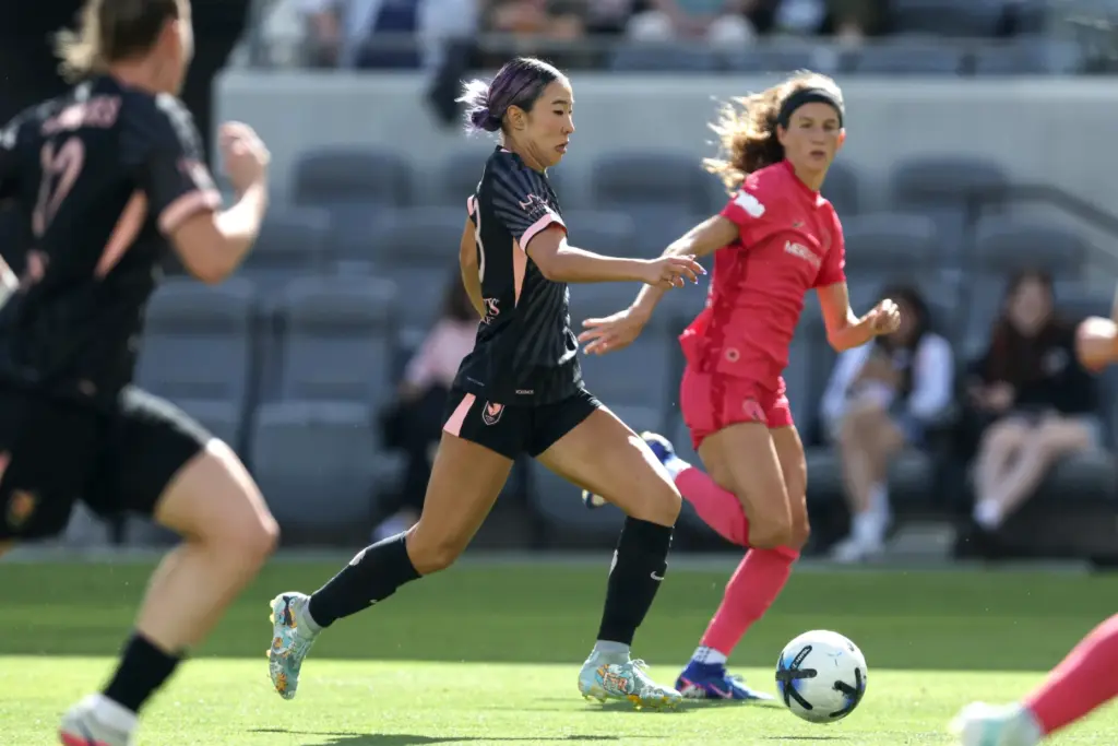 Angel City FC forward Jun Endo, center, moves the ball...