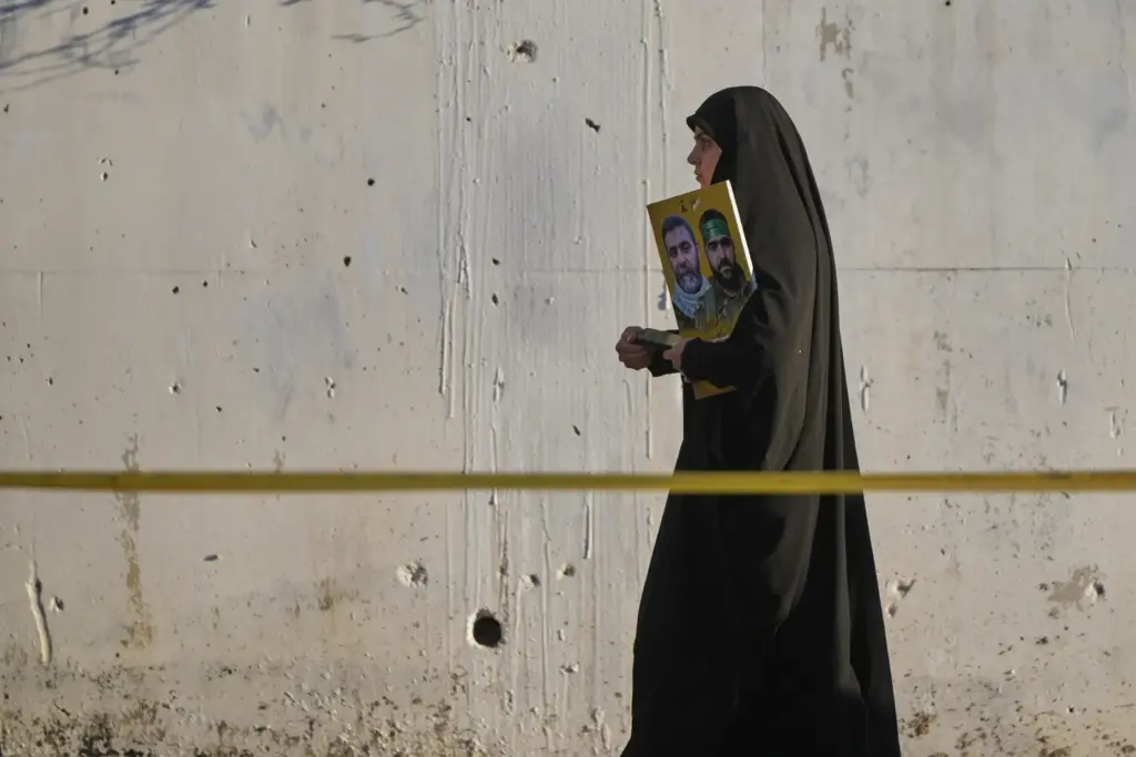 A woman holds a poster of Hezbollah fighters during a...