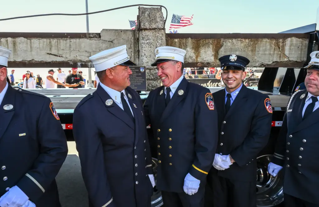 Retired NYFD firefighter accompany a piece of a steel beam...