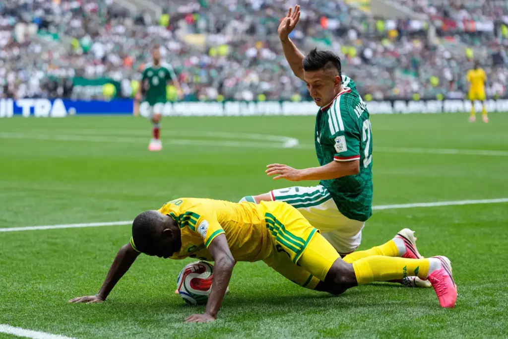 Mexico’s Roberto Alvarado vies for the ball with South Africa’s...