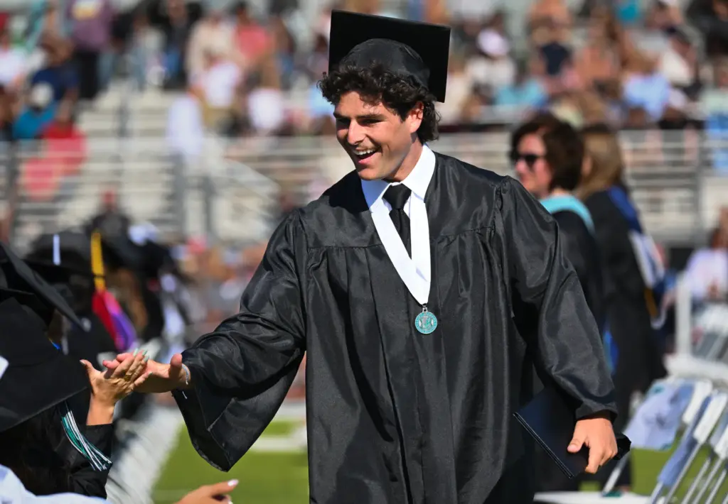 Graduate Brody Large greets friends after getting his diploma during...