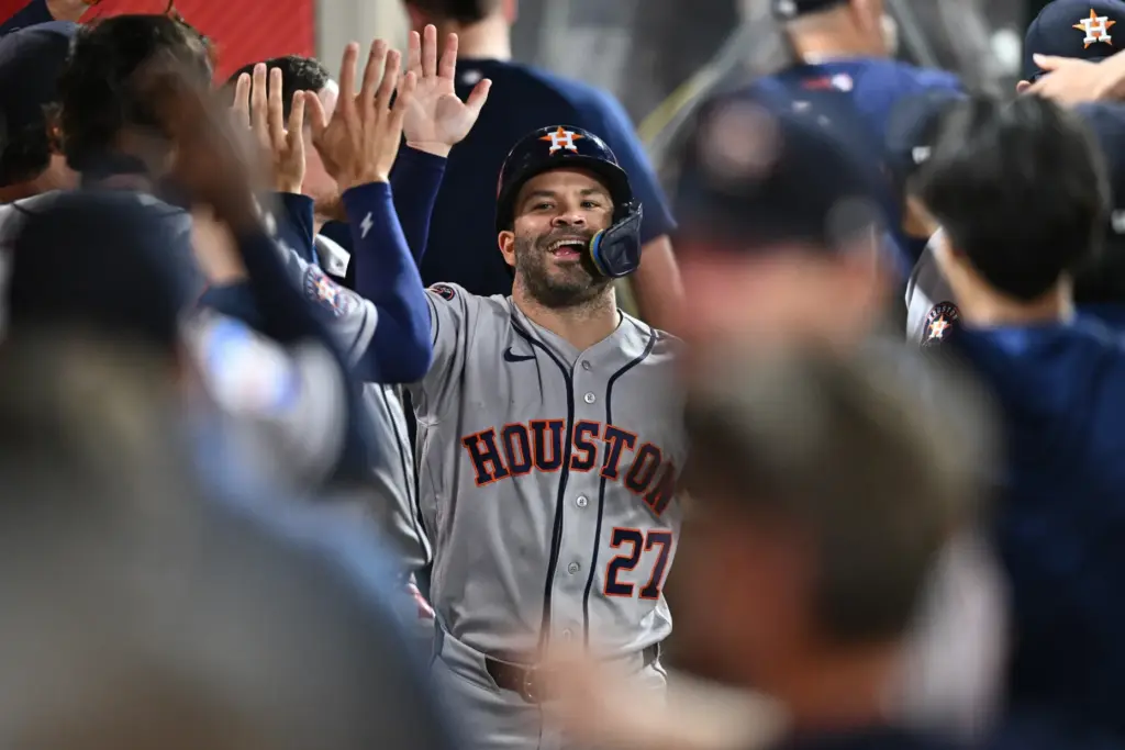 The Houston Astros’ Jose Altuve is greeted by teammates in...