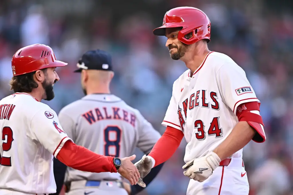 The Angels’ Trey Mancini, right, is greeted by first base...