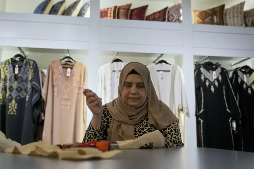 Palestinian weaver Rula Barakeh works on a handmade embroidered piece...
