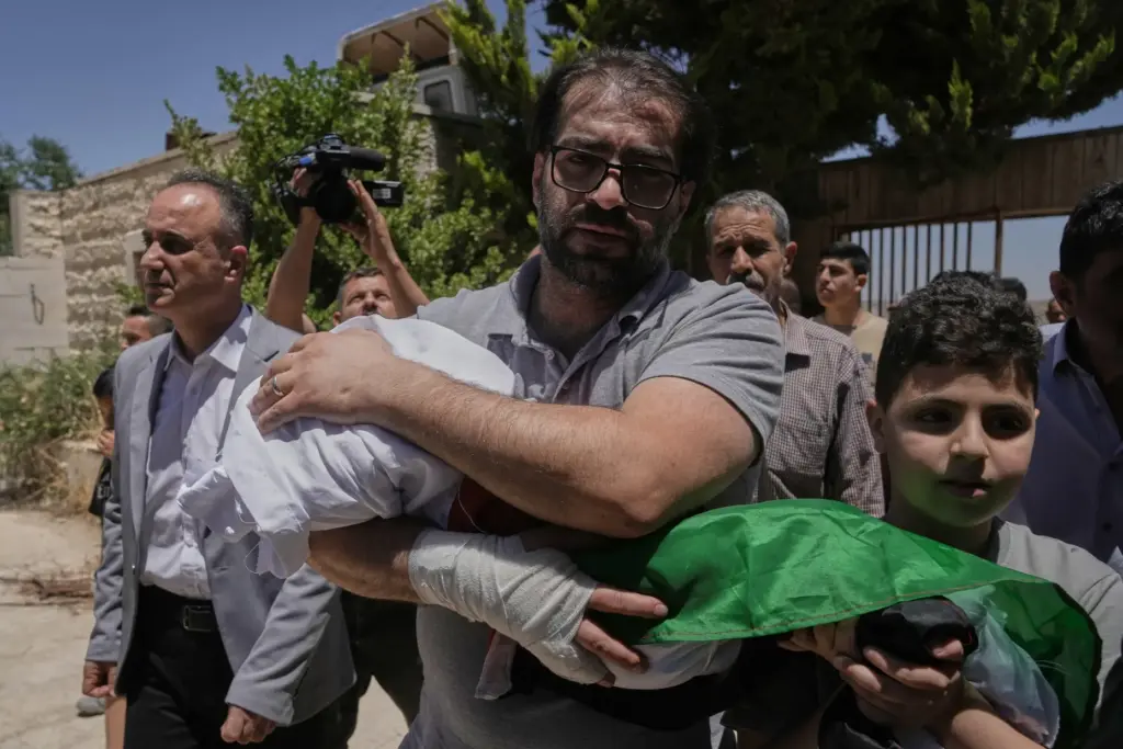 Fahd Abu Haikal, 41 carries the body of his seven...