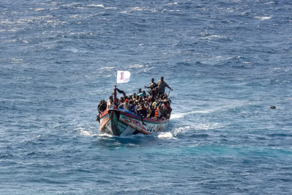 Migrants crowd a wooden boat as they sail to the port in La Restinga.