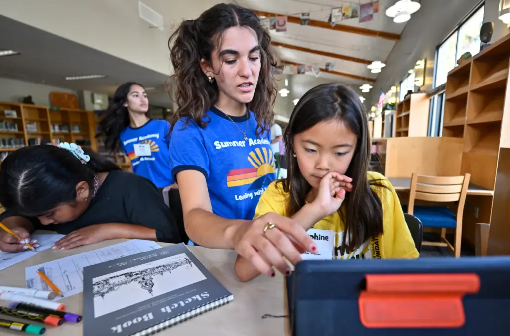 Intern Sarah Sanchez helps Josephine Woo during âPublish Your Own...