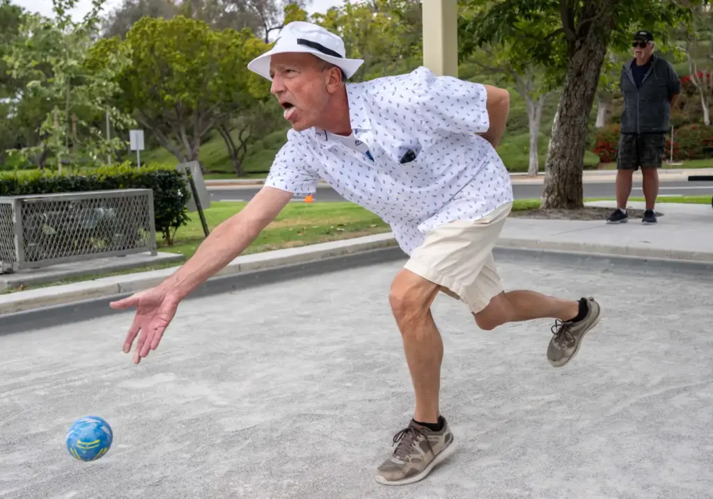 Steve Cryan of Mission Viejo rolls a bocce ball while...