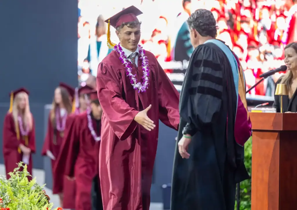 Lincoln Adams shakes hands with Principal Jason Allemann as he...