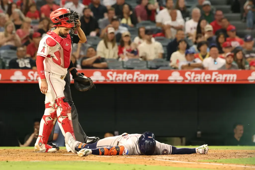 The Houston Astros’ Christian Walker lies on the ground after...