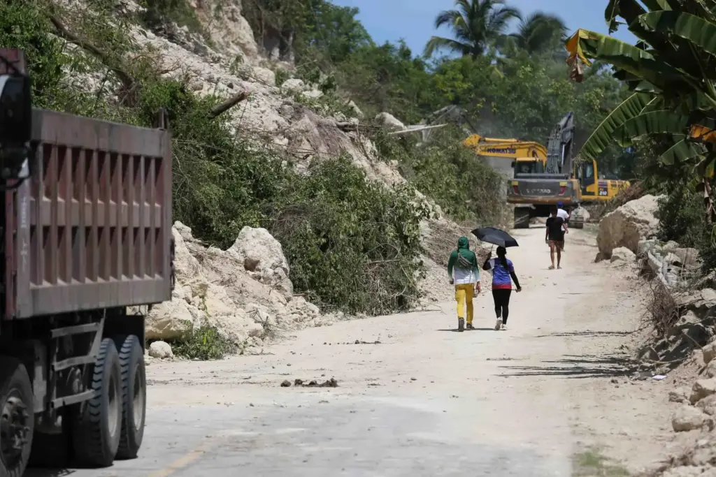 People walk past a landslide following an earthquake in Sarangani...