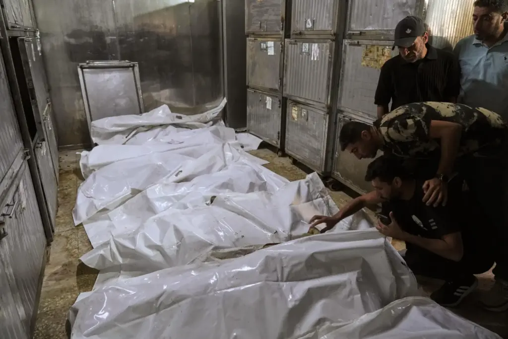 Palestinians mourn over the bodies of people killed in an...