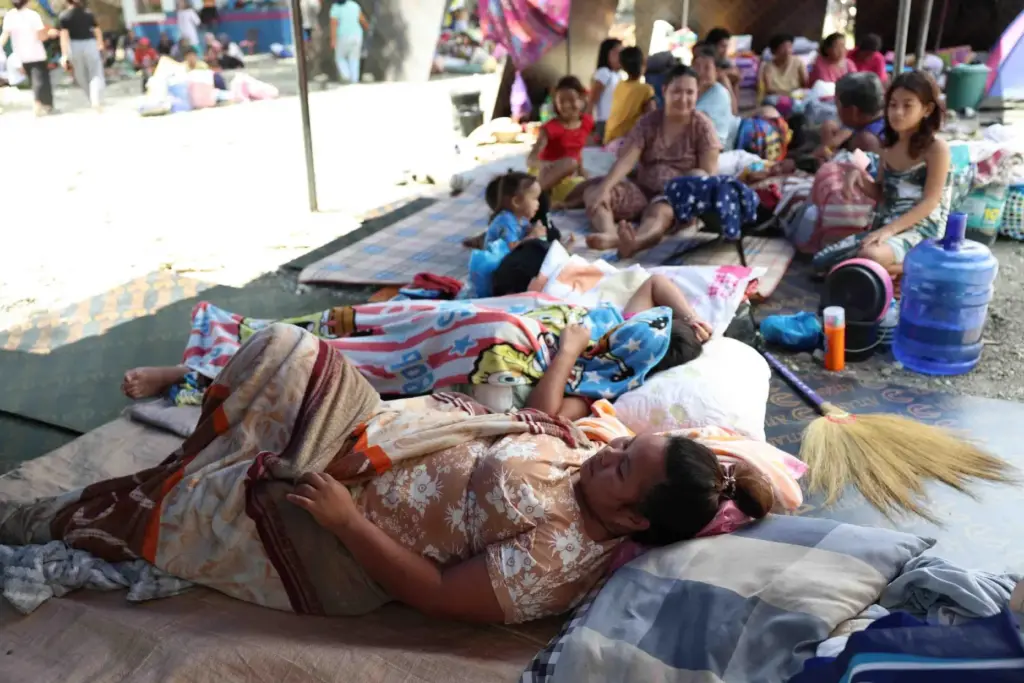 Residents take shelter in a field at a municipal hall...