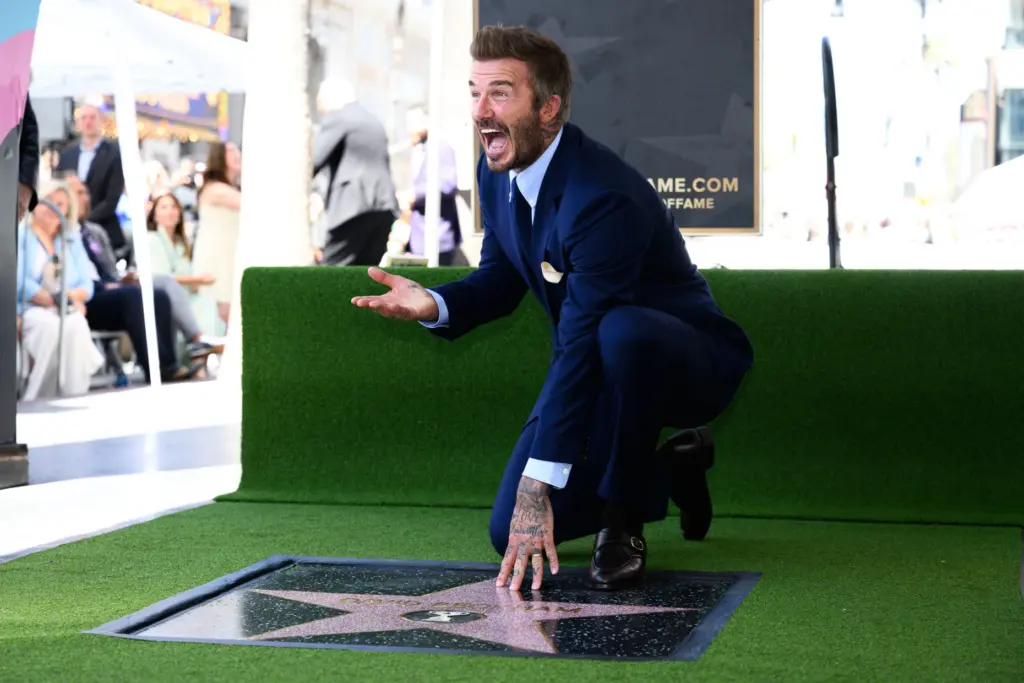 David Beckham poses with his new star on the Hollywood...