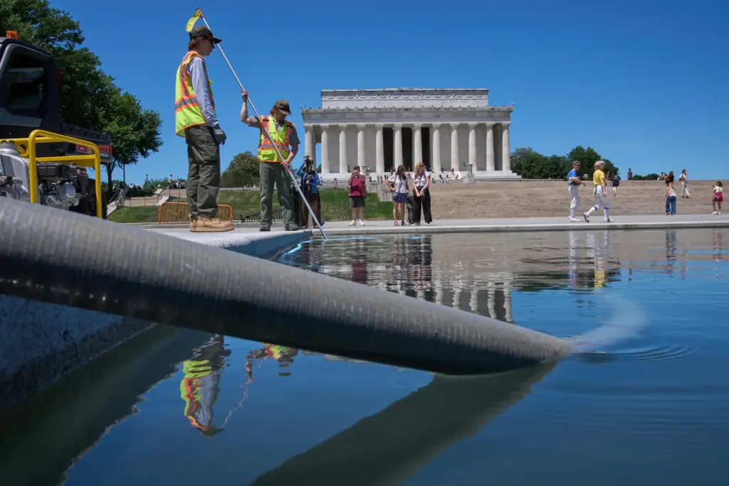 Members of the National Park Service work to clean the...