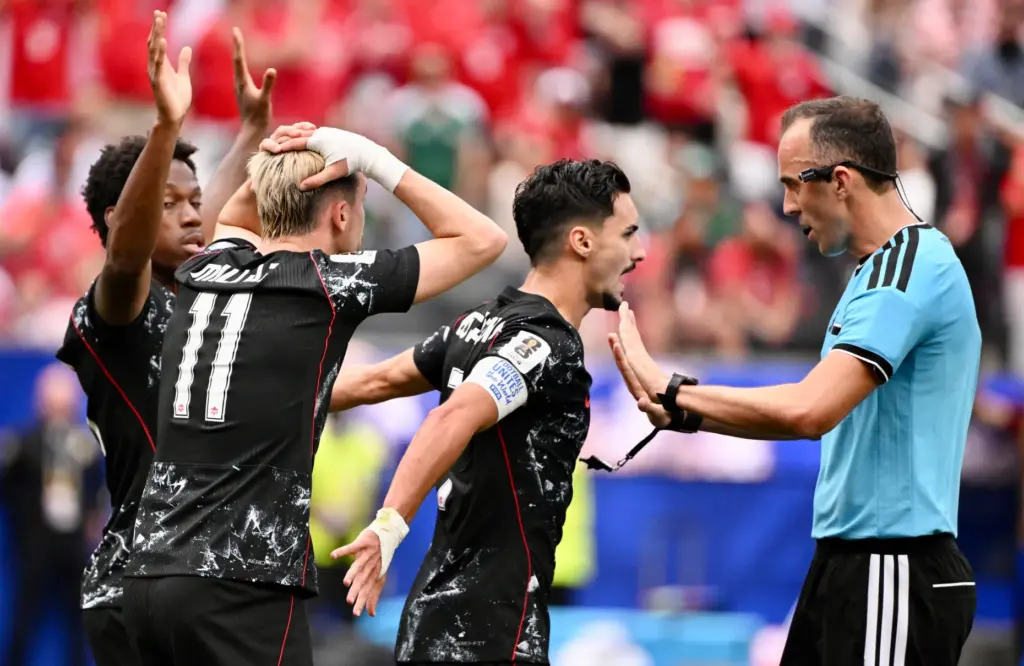 Canada midfielder Stephen Eustaquio (7) holds back teammates as he...