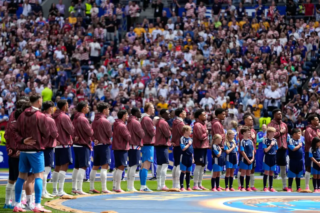 United States players stand during the national anthems before the...