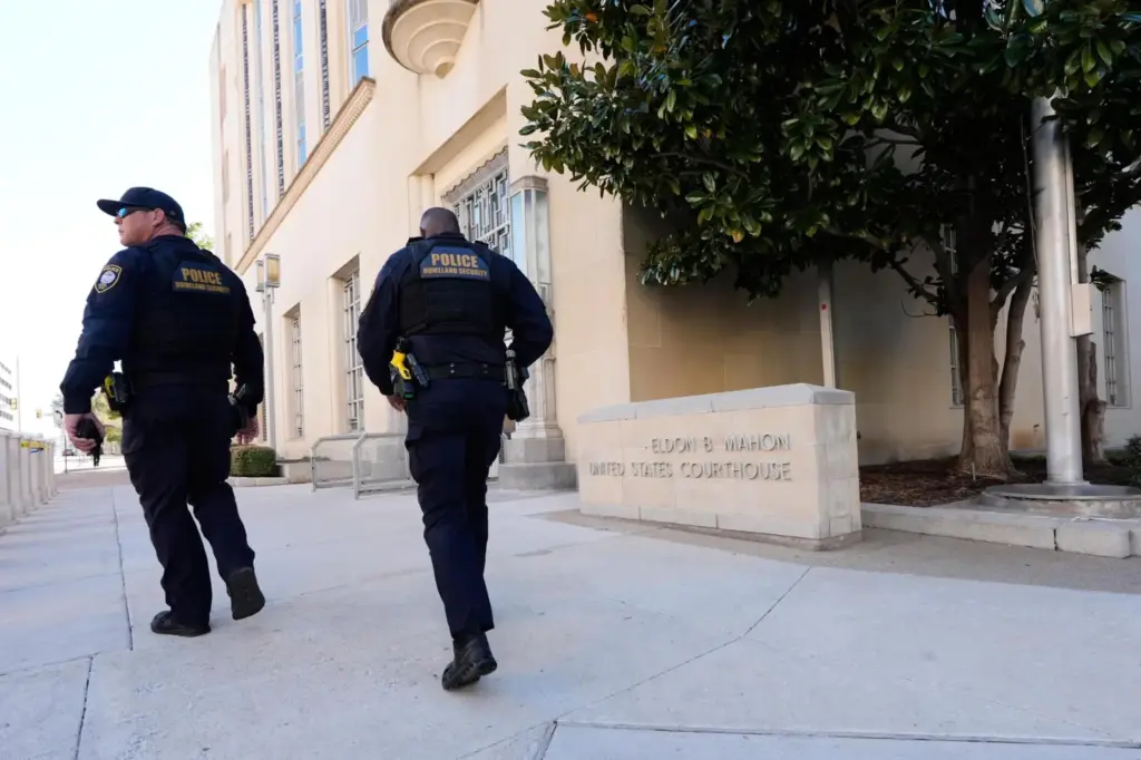 FILE – Officers with the Department of Homeland Security walk...