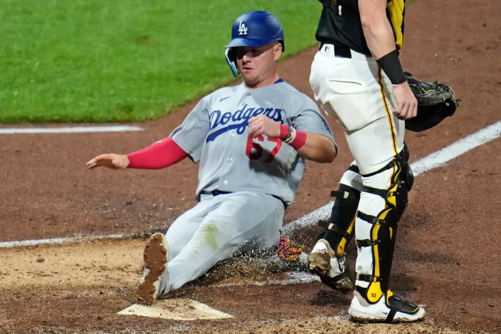 The Dodgers’ Ryan Ward, left, scores on a sacrifice fly...