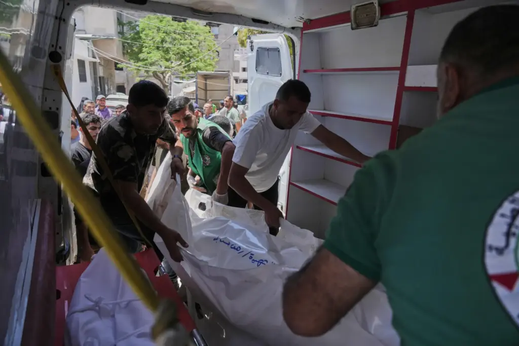 Palestinians carry the bodies of people killed in an Israeli...