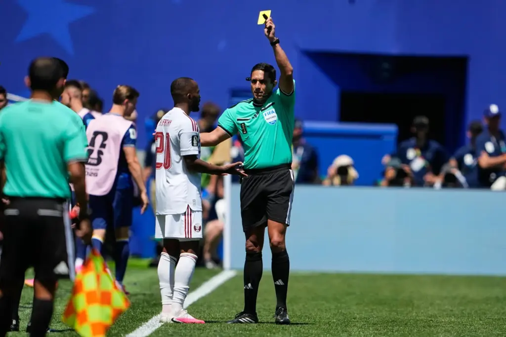 Referee JesÃºs Valenzuela shows Qatar's Ahmed Fathy a yellow card.