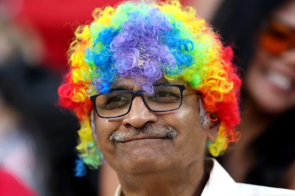A fan wears rainbow wig during the first half of...