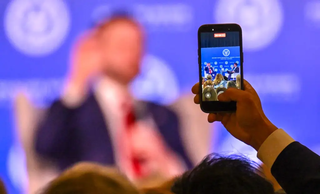 A visitor takes a video as Vice President JD Vance...