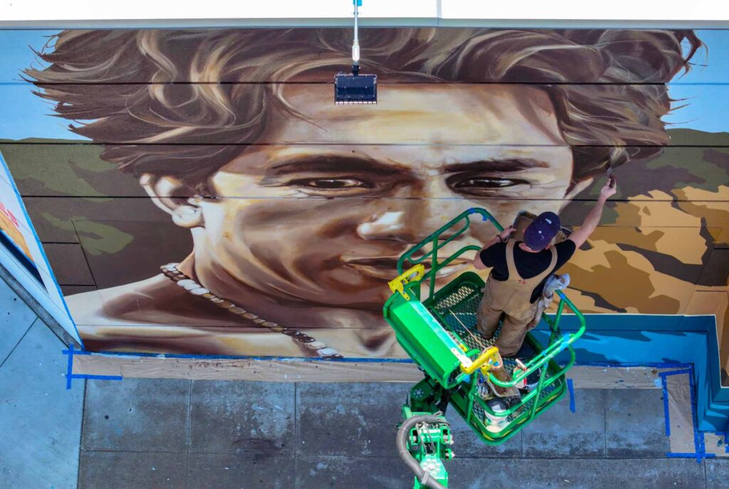 Artist Jack Stricker puts the finishing touches on a mural...