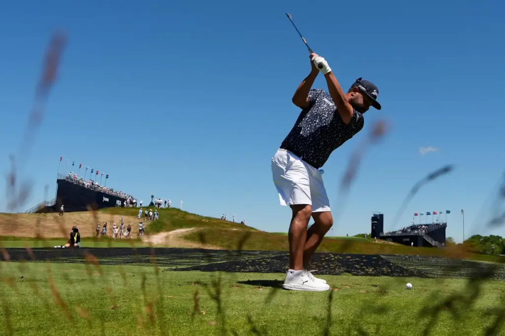 J.J. Spaun hits his tee shot on the 12th hole...