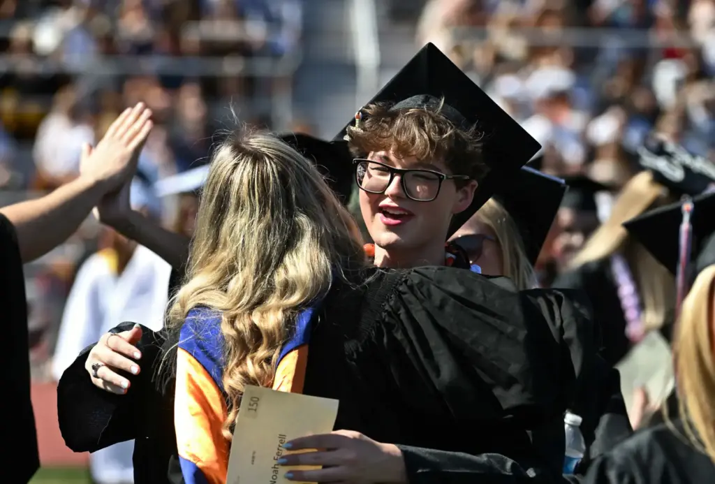 Noah Ferrell gives a teacher a hug at the start...