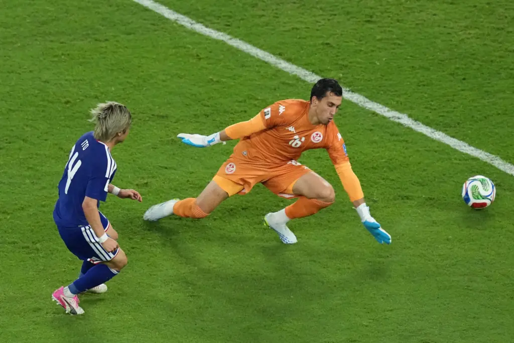 Junya Ito scores Japan’s third goal past Tunisia goalkeeper Aymen...