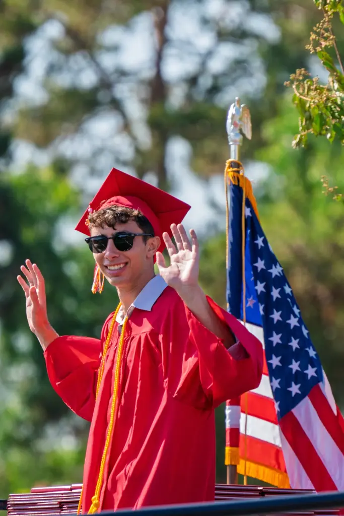 Daniel Lavi waves to fellow graduates following his speech during...